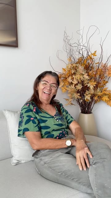 Paciente sorrindo na recepção da Clínica Alevo
